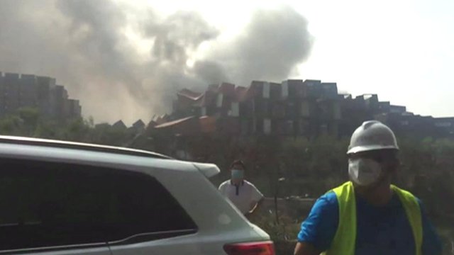 Debris and smoke at explosion site in Tianjin