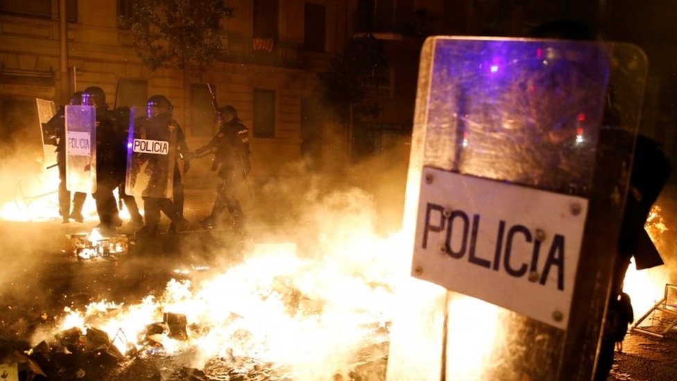 Полицейские стоят на страже среди горящих баррикад в Барселоне. Фото: 16 октября 2019 г.