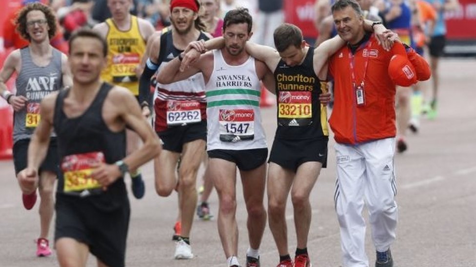 Мэтт Рис и волонтер помогают Дэвиду Уайету преодолеть финишную черту Лондонского марафона в 2017 году