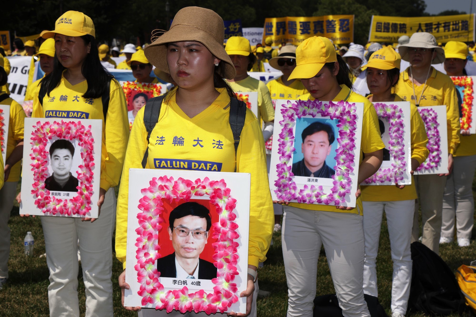 Falun Gong protesters hold images of members they say were killed by the Chinese state