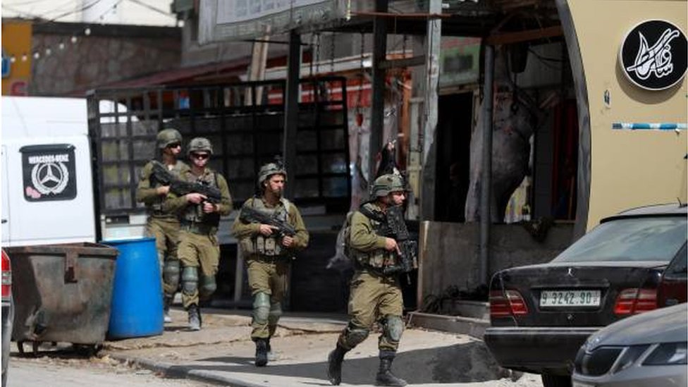 جنود إسرائيليون ينتشرون داخل أحد شوارع بلدة حوارة