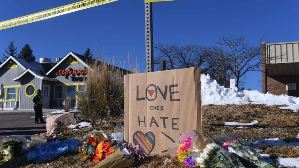 Flores y un letrero que dice "amor sobre el odio".