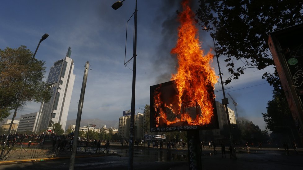 Демонстранты зажигают пожары во время столкновения с ОМОНом во время акции протеста 21 октября 2019 года в Сантьяго, Чили