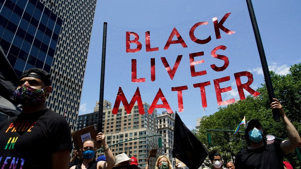 Люди держат табличку, когда принимают участие в совместном марше ЛГБТК и Black Lives Matter в 51-ю годовщину беспорядков в Стоунволл в Нью-Йорке, штат Нью-Йорк, США, 28 июня 2020 года.