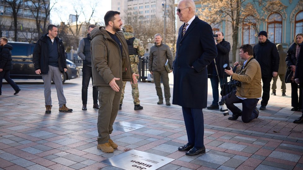 A handout photo made available by the Ukrainian Presidential Press Service on 20 February 2023 shows Ukrainian President Volodymyr Zelensky (L) with US President Joe Biden visiting the "Walk of the Brave" on Constitution Square near a plaque dedicated to the US leader, in Kyiv (Kiev),