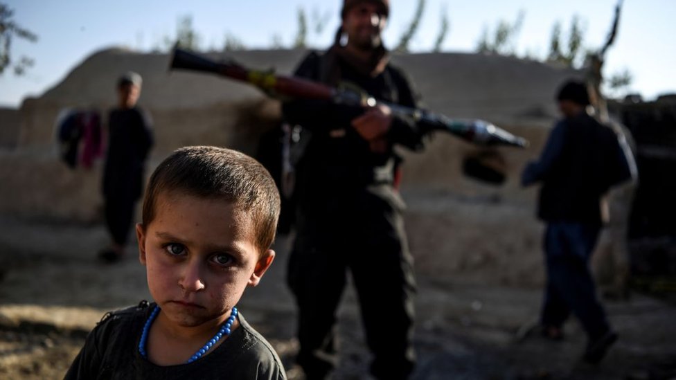 Niño junto a extremistas talibanes.