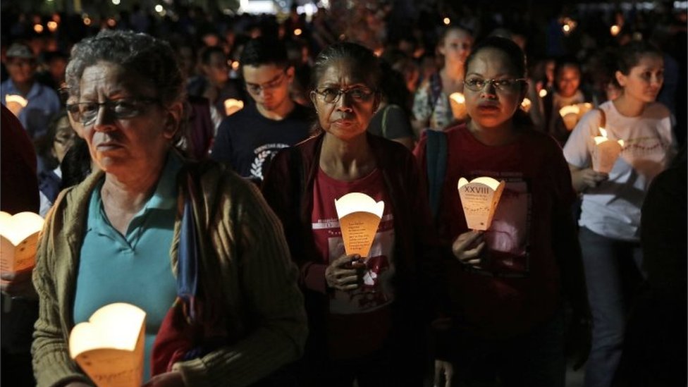 Люди держат фонари, когда сотни сальвадорцев присоединяются к процессии в ознаменование годовщины убийства шести священников-иезуитов и двух женщин элитной армией в Сан-Сальвадоре, Сальвадор, 11 ноября 2017 г.