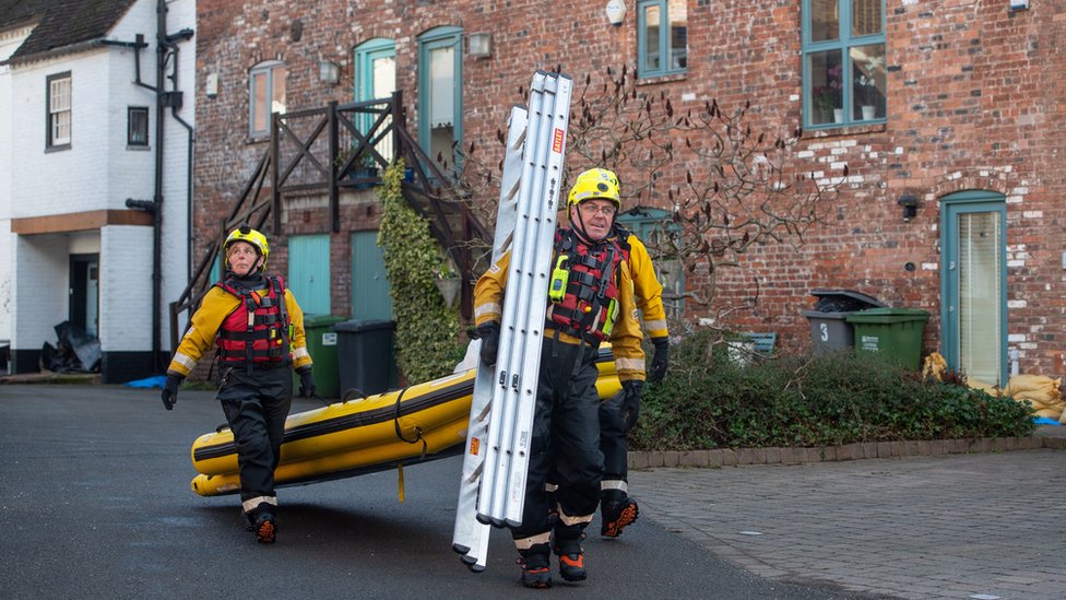 Пожарные и спасатели несут лестницы и надувной плот в Бьюдли, Вустершир,
