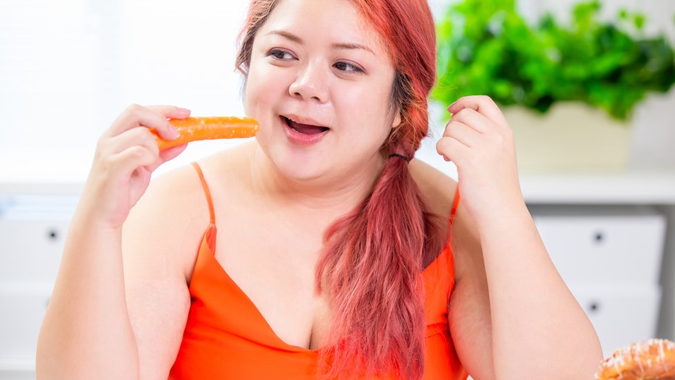 žena jede šargarepu