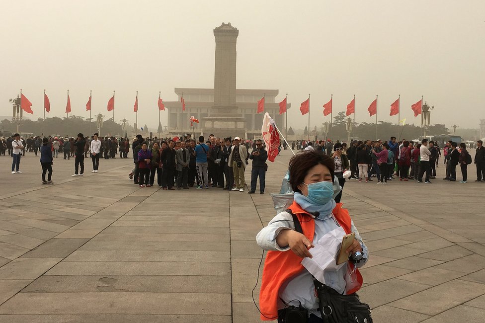 Люди посещают площадь Тяньаньмэнь, когда песчаная буря обрушилась на Пекин, Китай, 4 мая 2017 года.