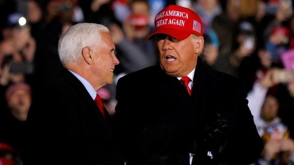 US President Donald Trump talks to Vice President Mike Pence, as he holds a campaign rally at Gerald R. Ford International Airport in Grand Rapids, Michigan, US on 2 November 2020