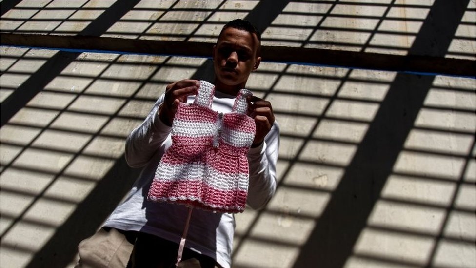 An inmate poses with a crochet clothing creation as part of "Ponto Firme" project in the Adriano Marrey maximum security penitentiary in Guarulhos, Brazil on May 22, 2019