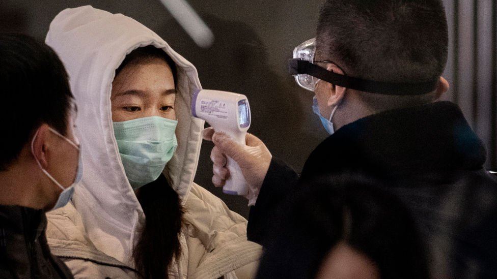 Koronavirüs riski nedeniyle Pekin otogarına ulaşan yolcuların vücut ısıları ölçülüyor.