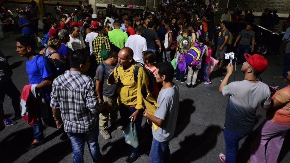 Гондурасские семьи выстраиваются в очередь, чтобы сесть в автобус, который отправляется из столичного центра Сан-Педро-Сула, в 300 км к северу от Тегусигальпы, и направляется к границе с Гватемалой 9 апреля 2019 года.