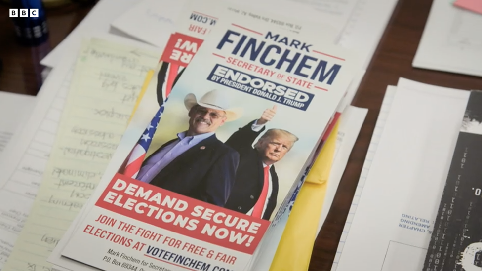 Afiche de campaña de Mark Finchem que lo muestra con Donald Trump