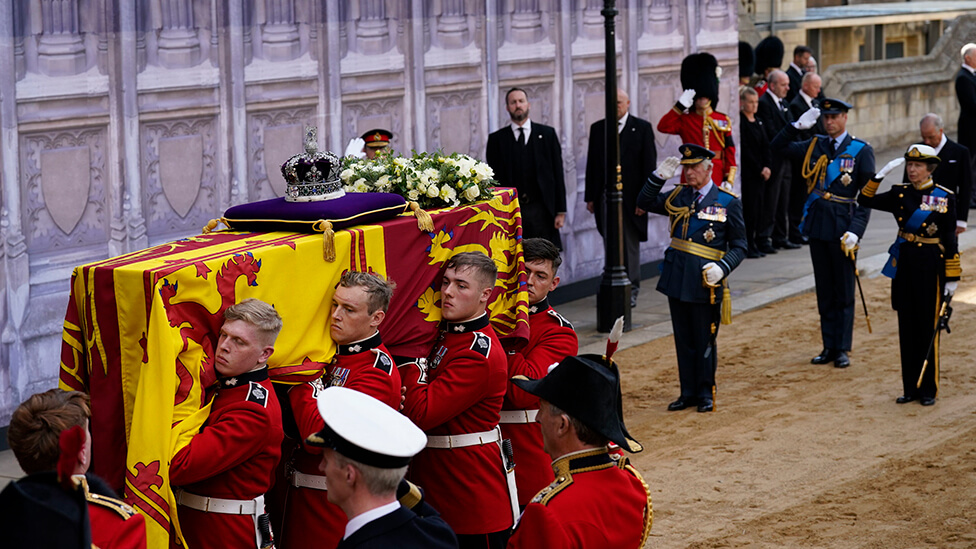 Member of the Royal Family saluting as the coffin is carried into Westminster Hall