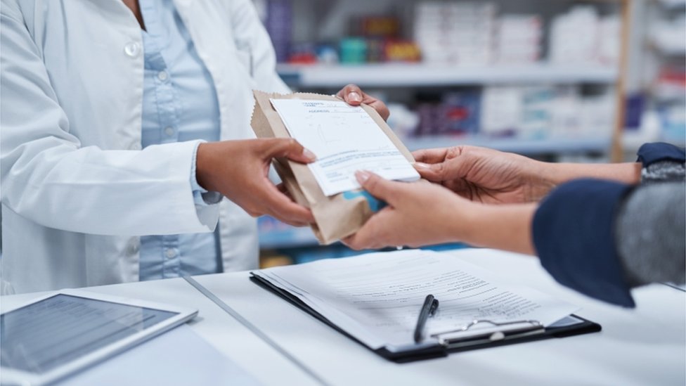 Неузнаваемый фармацевт крупным планом помогает покупателю в аптеке