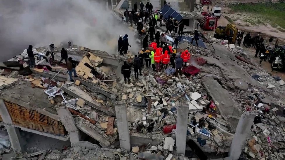 Rescuers search through rubble of collapsed buildings following an earthquake, in the rebel-held town of Sarmada, Syria on 6 February 2023