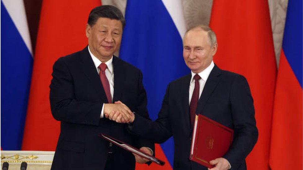 بوتين وشي جنبنغ يتصافحان بعد توقيع اتفاقيات بين البلدين في القمة التي جمعتهما في موسكو في 22 مارس/ آذار
