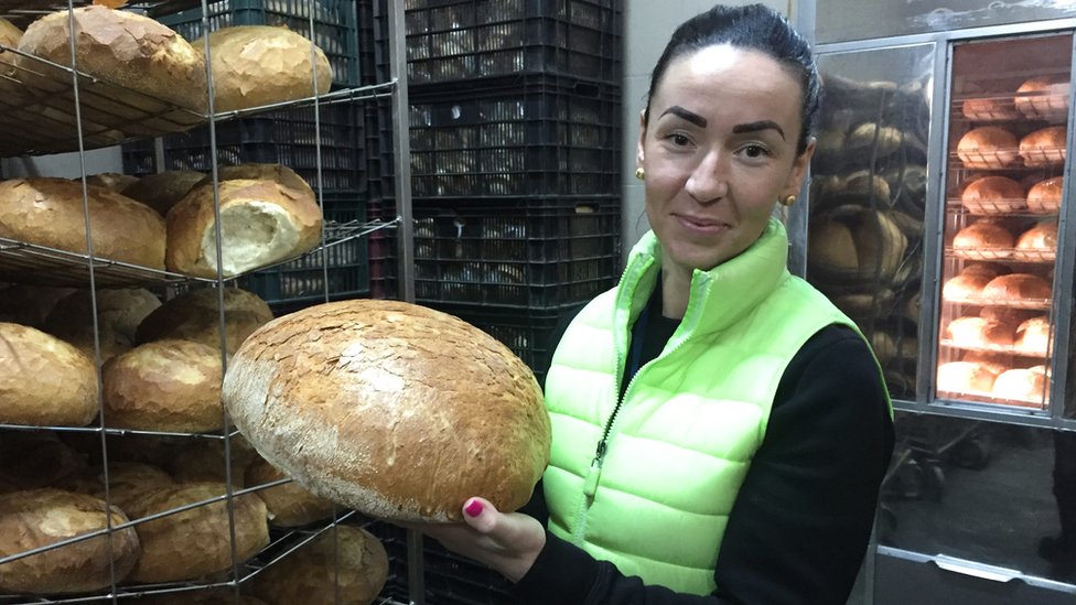 Владелец пекаря Каталин Колло держит в руках большую булочку