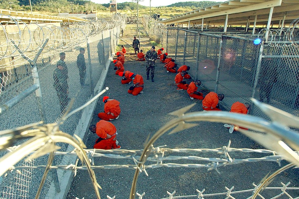 محتجزون يرتدون بدلات برتقالية في معسكر الاحتجاز في غوانتانامو في كانون الثاني / يناير 2002