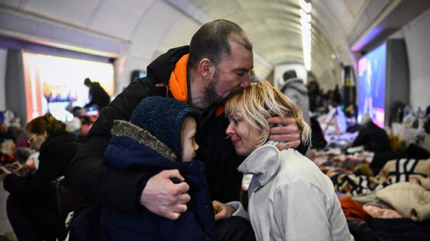 Família abraçada em estação de metrô de Kiev