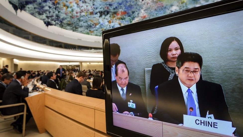 Chinese Vice Minister of Foreign Affairs Le Yucheng (R) is seen on a TV screen as he attends the Universal Periodic Review of China before the United Nations (UN) Human Rights Council on November 6, 2018 in Geneva
