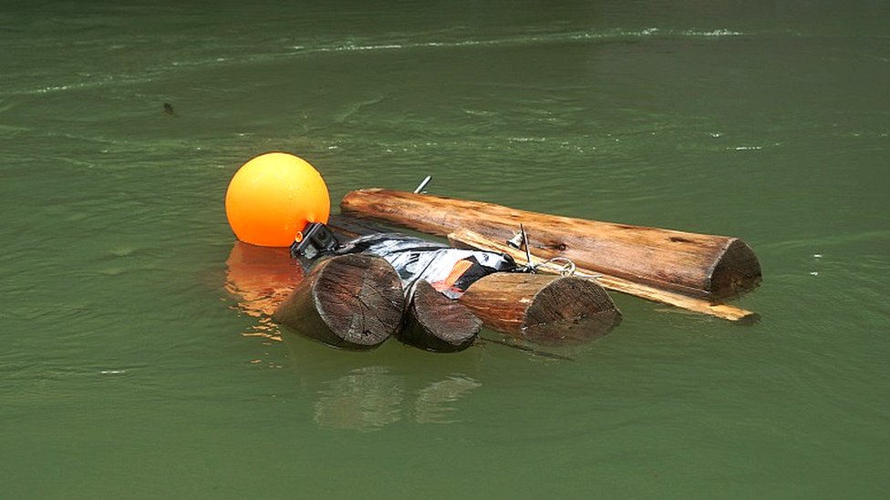 Boneco de madeira flutua em rio da Colômbia