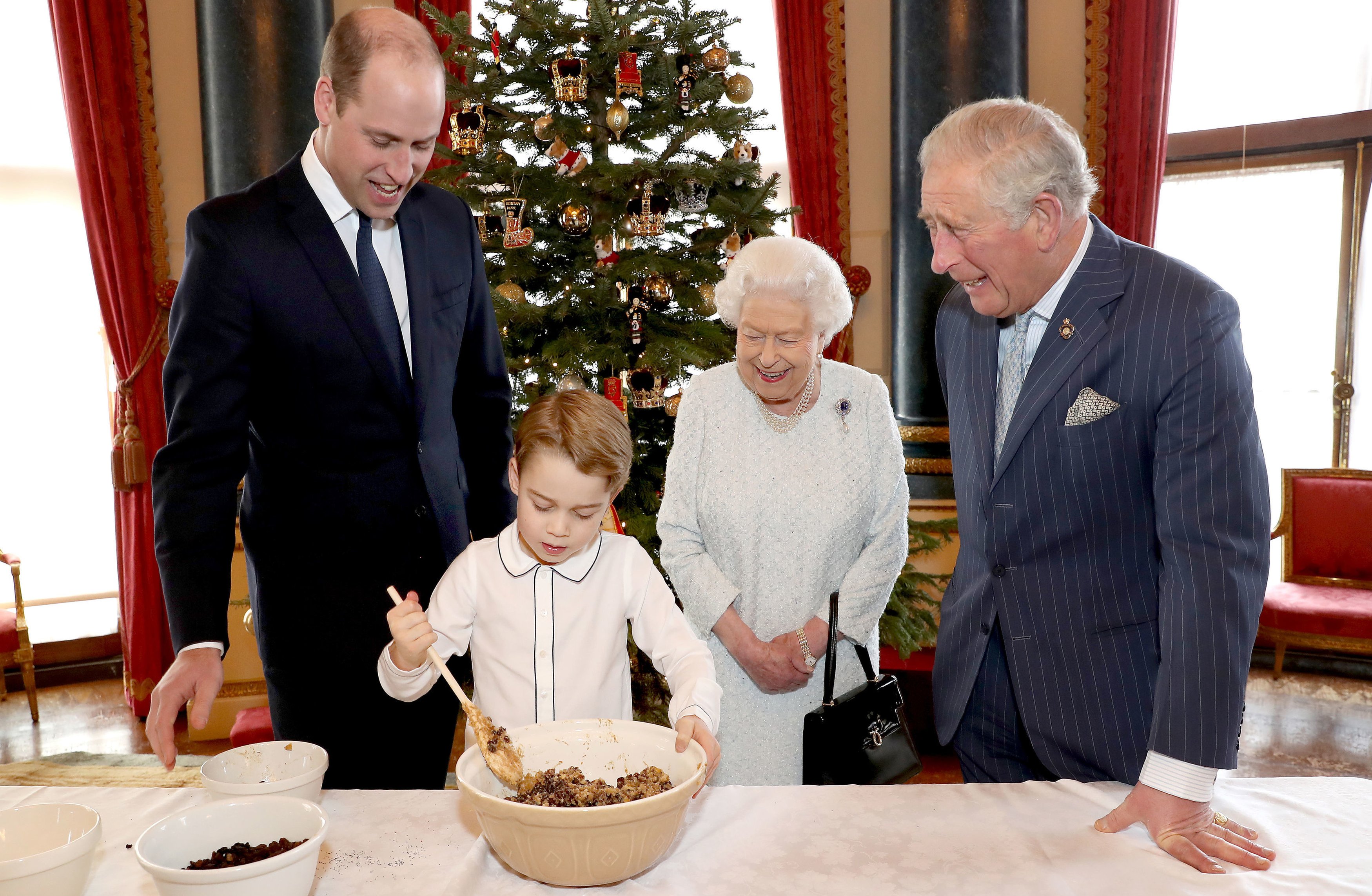 Королева Елизавета II, принц Уэльский, герцог Кембриджский и принц Джордж готовят особые рождественские пудинги в Музыкальной комнате Букингемского дворца в Лондоне в рамках инициативы Королевского британского легиона «Вместе на Рождество»