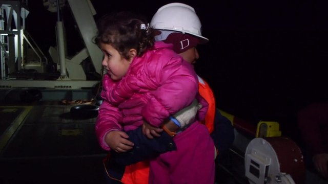 Girl is carried aboard a rescue boat