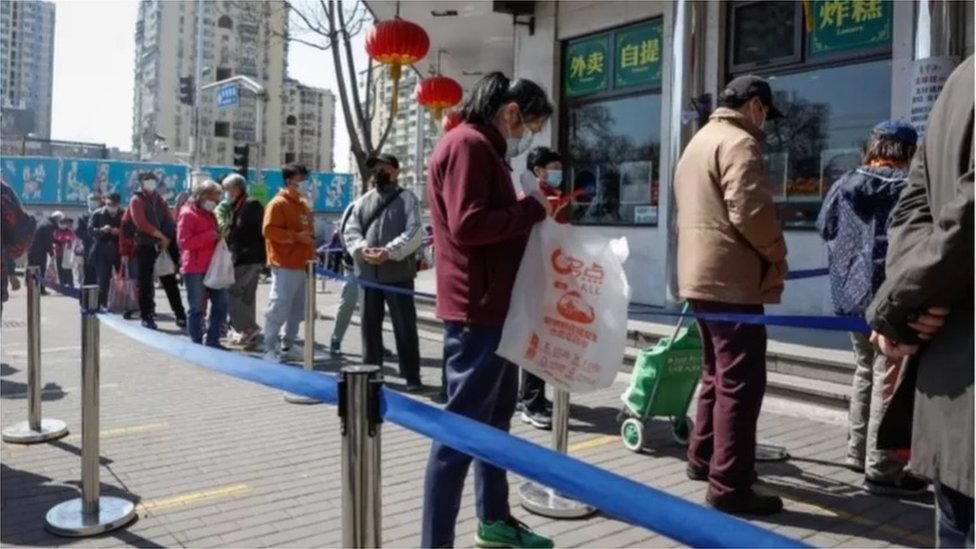中國持續的封鎖措施將對經濟造成影響（圖為人們排隊在北京的一家商店購買食品）。