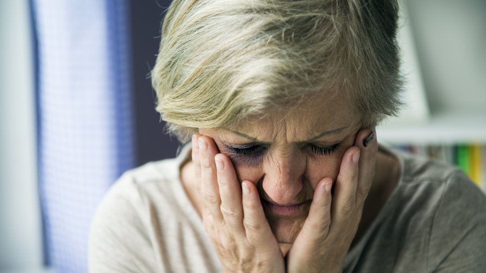   A woman holds her face 