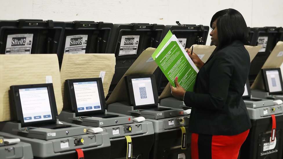 Mujer revisa máquinas de votación