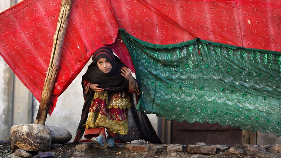 На фотографии, сделанной в это воскресенье, 29 ноября 2015 г., девушка из вынужденных переселенцев выглядывает из палатки после того, как ее семья покинула свою деревню в районе Родат Джалал-Абад к востоку от Кабула