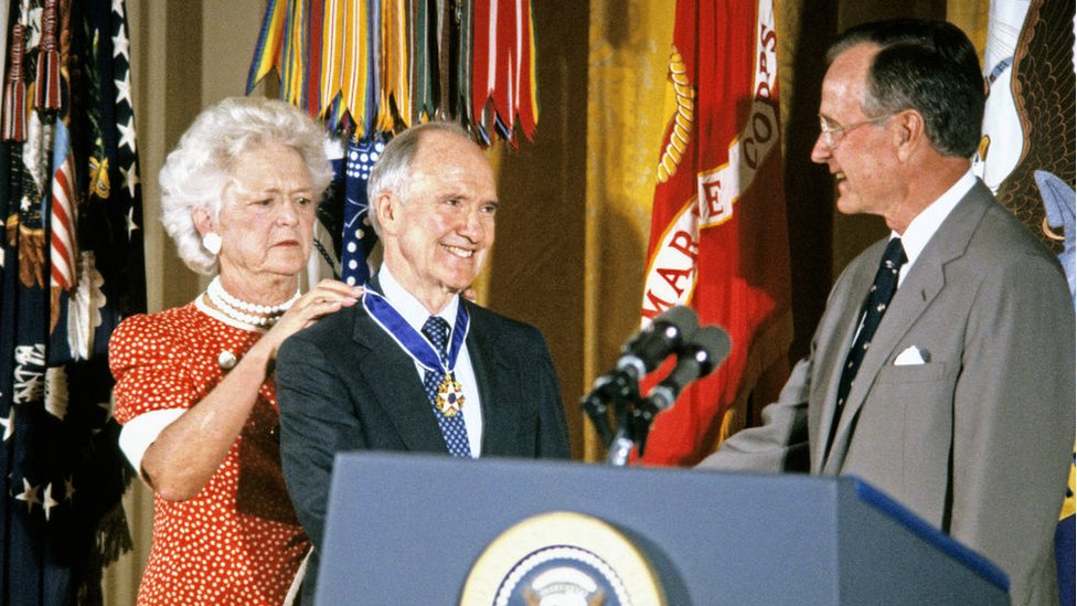 Первая леди США Барбара Буш вешает президентскую медаль свободы на шею советника по национальной безопасности Брента Скоукрофта, когда он пожимает руку президенту США Джорджу Бушу