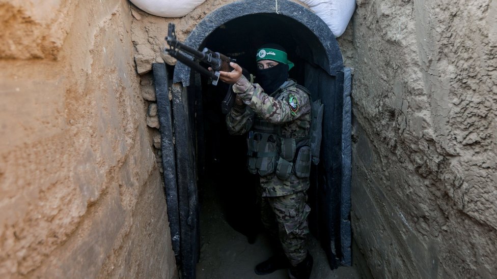 A fighter from Hamas's military wing, the Izzedine al-Qassam Brigades, stands in front of a tunnel in the Maghazi camp, in central Gaza (19 Jul 2023)