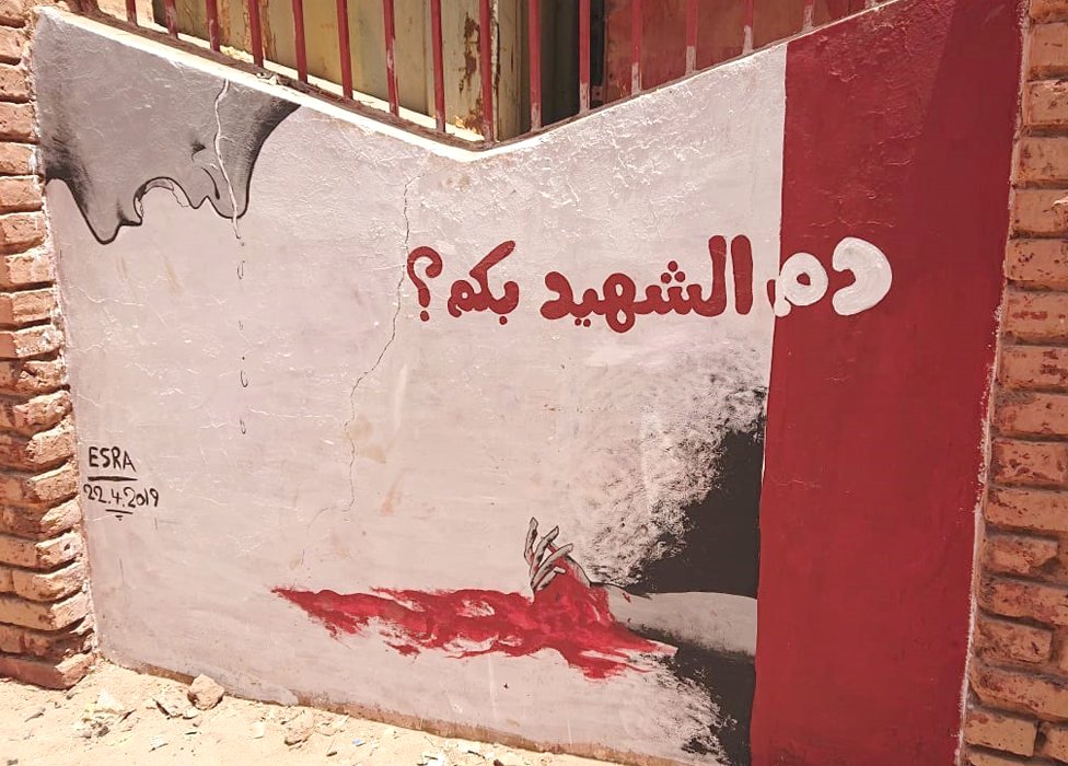جدارية تحمل عبارة "دم الشهيد بكم؟" في الخرطوم