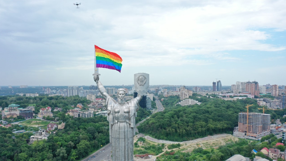 A drone flies an LGBT flag near the Statue of the Motherland in Kyiv, Ukraine