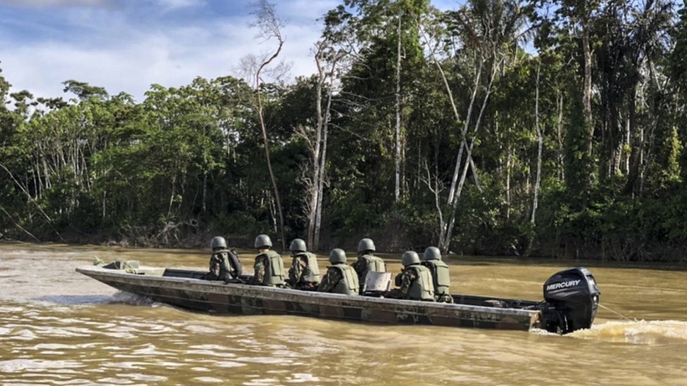 Militares em barco no rio
