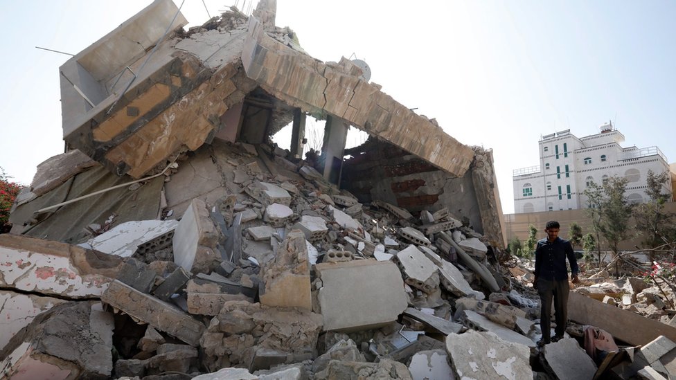 A man walks through the remains of a building destroyed in a Saudi-led coalition air strike in rebel-held Sanaa, Yemen (7 October 2021)