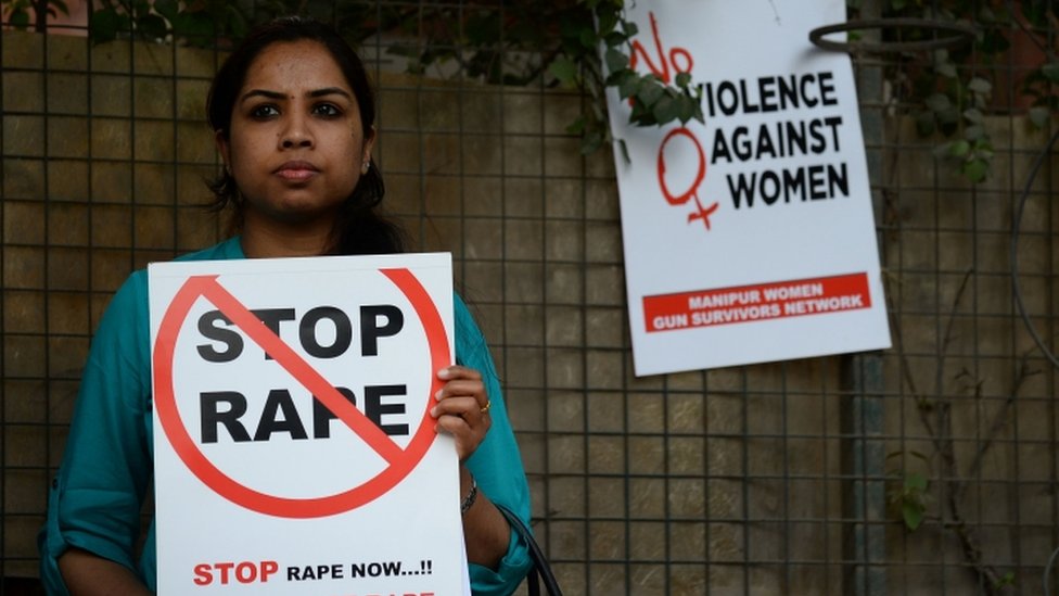 A social activist hold placards during a protest against rape at Hauz Khas village in Delhi on February 21, 2017