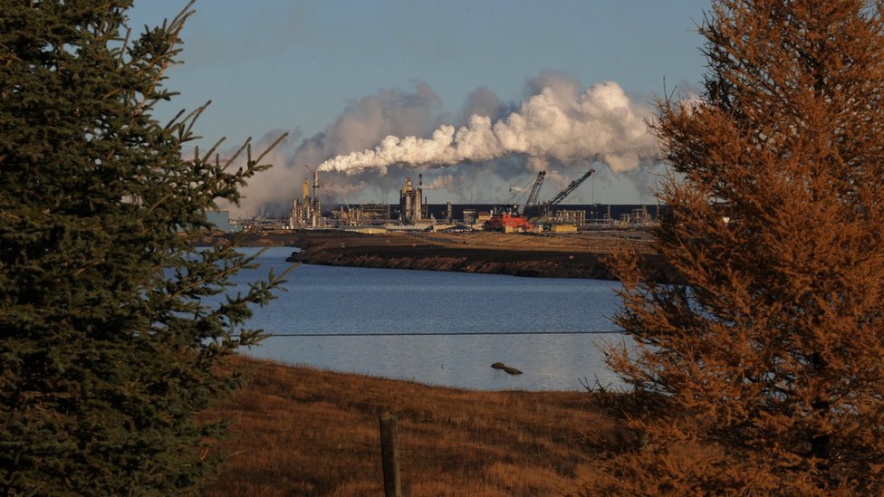 Завод по добыче нефтеносных песков Syncrude за озером, извлеченным из старой шахты недалеко от города Форт МакМюррей в провинции Альберта, Канада, 22 октября 2009 года.