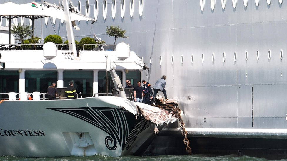 Поврежденное туристическое судно River Countess изображено после того, как 2 июня 2019 года оно было сбито круизным лайнером MSC Opera (R), потерявшим управление при заходе в док в Венеции, Италия