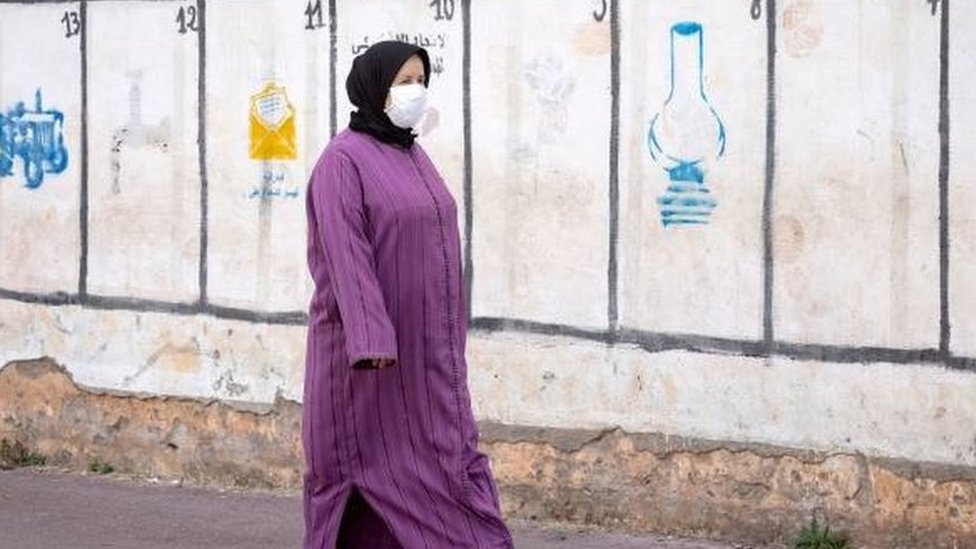 سيدة مغربية تمر قرب رموز انتخابية للمرشحين في الانتخابات البرلمانية المقبلة في العاصمة الرباط