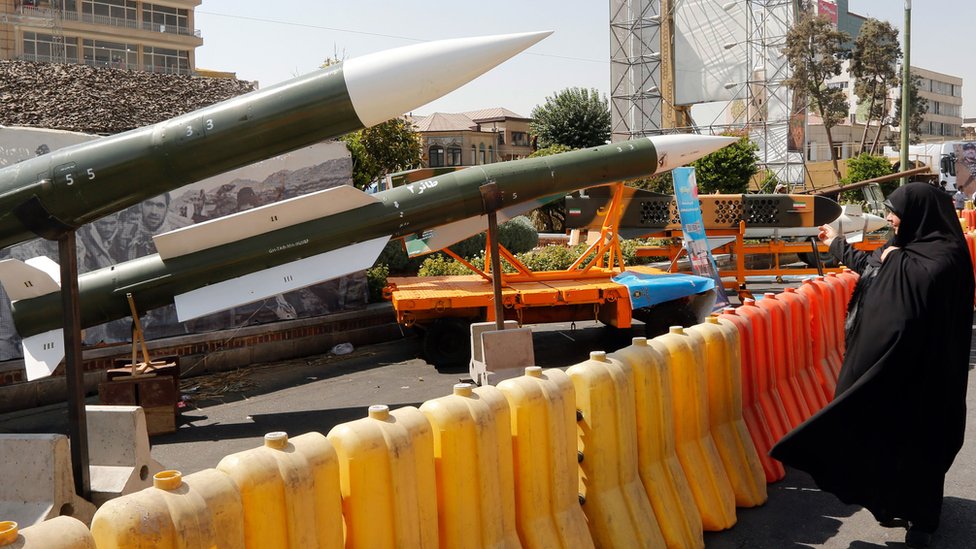 A woman looks at missiles on display during a street exhibition in Tehran, Iran