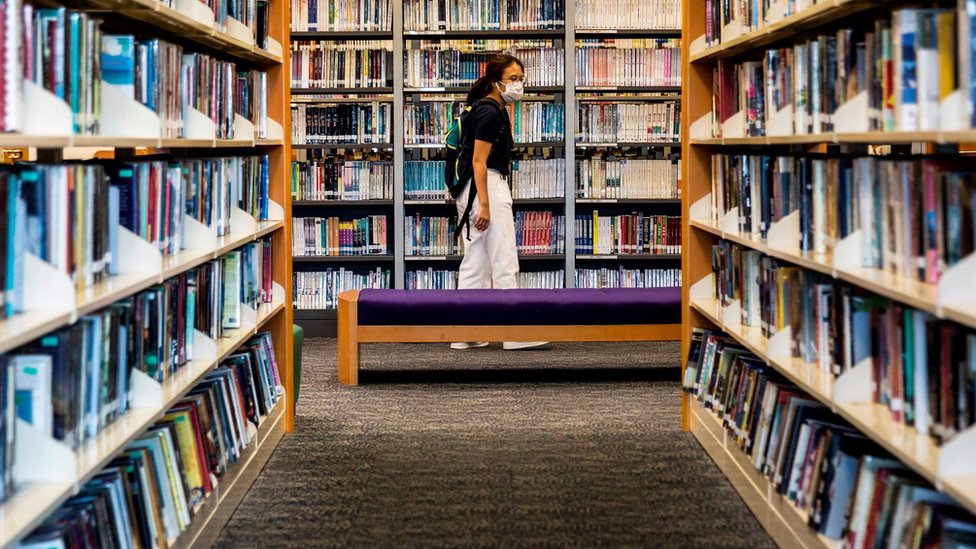 A women looks at books in a public library in Hong Kong on July 4, 2020. - Books written by prominent Hong Kong democracy activists have started to disappear from the city's libraries, online records show, days after Beijing imposed a draconian national security law on the finance hub.