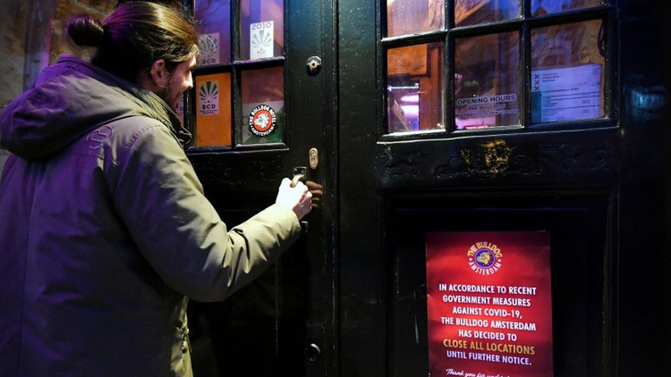 Un hombre entrando en un bar en el Barrio Rojo de Ámsterdam.