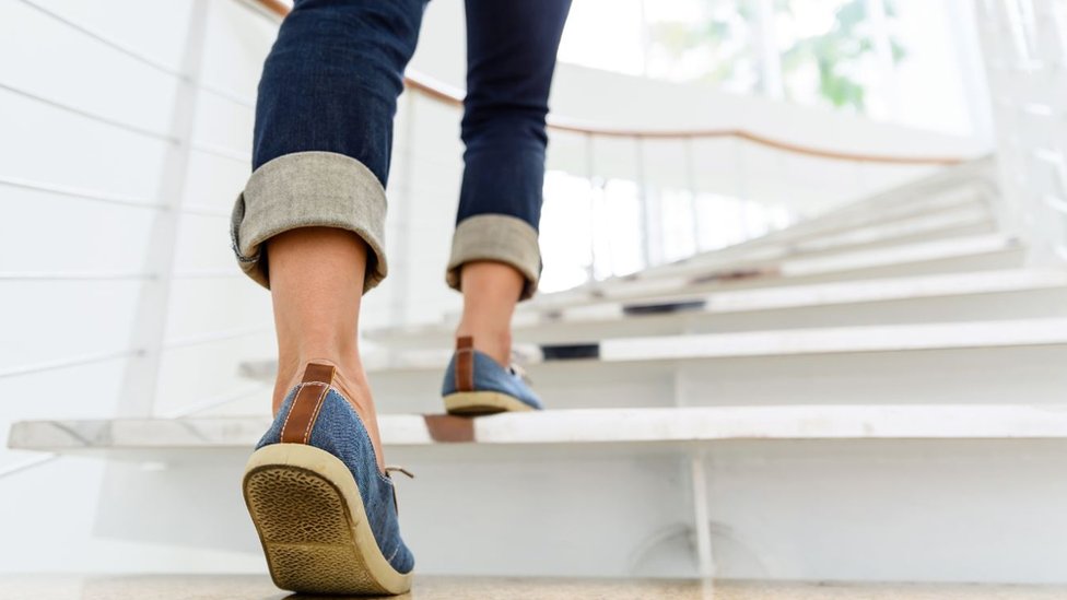 Una mujer subiendo las escaleras