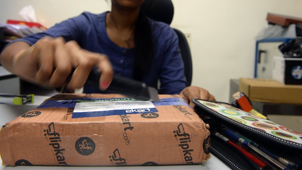 Индийская женщина открывает посылку в своем офисе после того, как заказала ее на сайте интернет-магазинов в Мумбаи в 2013 году.