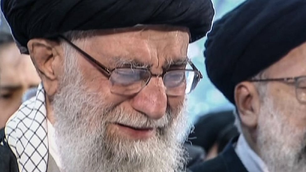 На кадре из видео Iran Press видно, как верховный лидер Ирана аятолла Али Хаменеи (слева) плачет, читая молитву перед гробом иранского военачальника Касема Сулеймани во время похоронной процессии в столице Тегеране 6 января 2020 года